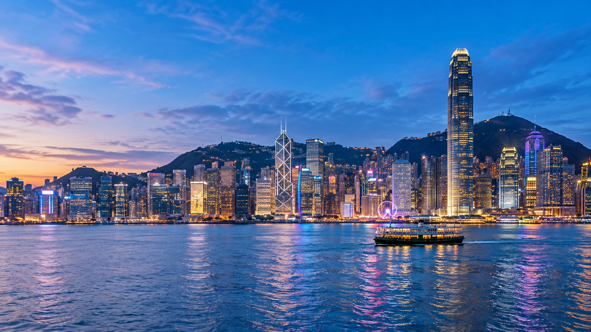 The skyscrapers of Central across Victoria Harbour at dusk
