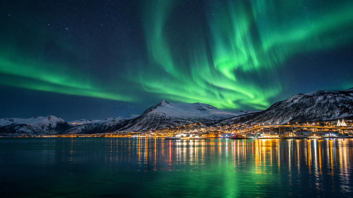 The Northern Lights over the fjord and mountains at Tromsø