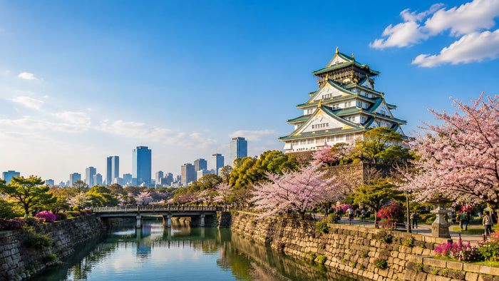 Osaka Castle lit at dusk above its stone walls